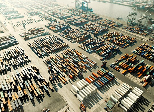 foto de cima de um porto com diversos containers