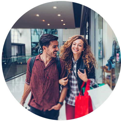 Casal passeando em um shopping segurando sacolas de compras