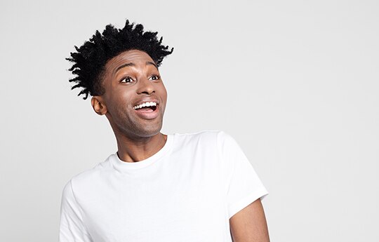 rapaz sorrindo e olhando para o lado.