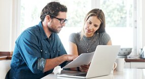 Casal de clientes olhando para uma fatura de cartão de crédito.