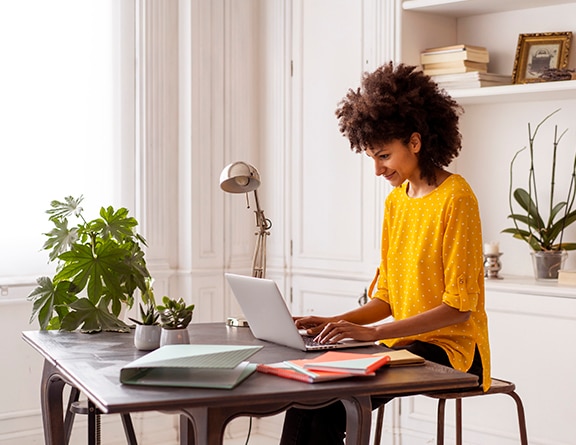 cliente Itaú usando o computador para acessar o site e conhecendo os servisos e produtos disponíveis