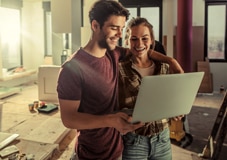 Casal de clientes Itaú Personnalité consultando sua conta em um notebook.