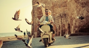 Cliente Itaú Personnalité andando de moto com aves voando ao fundo.