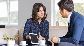 especialista em investimentos do Itaú Private, mostrando para o cliente as possibilidades de geração de renda em um tablet