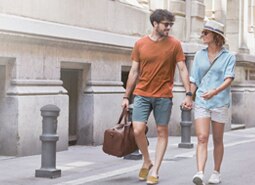 Casal de clientes itaú passeando em um parque durante uma viajem