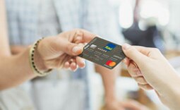 mão de cliente Itaú Uniclass segurando um cartão de crédito