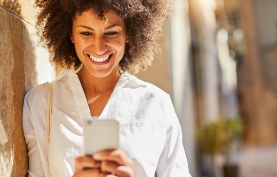 mulher sorrindo a abrindo uma conta Itaú Uniclass pelo celular
