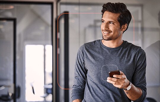 Cliente Itaú com seu celular na mão e olhar confiante