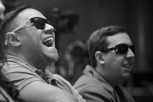 Colaboradores deficientes visuais, sorrindo em uma palestra do Itaú.