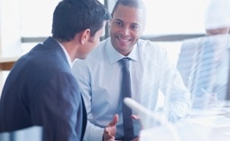 Homem cliente Itaú conversando com o gerente da sua conta para renegociar suas dívidas