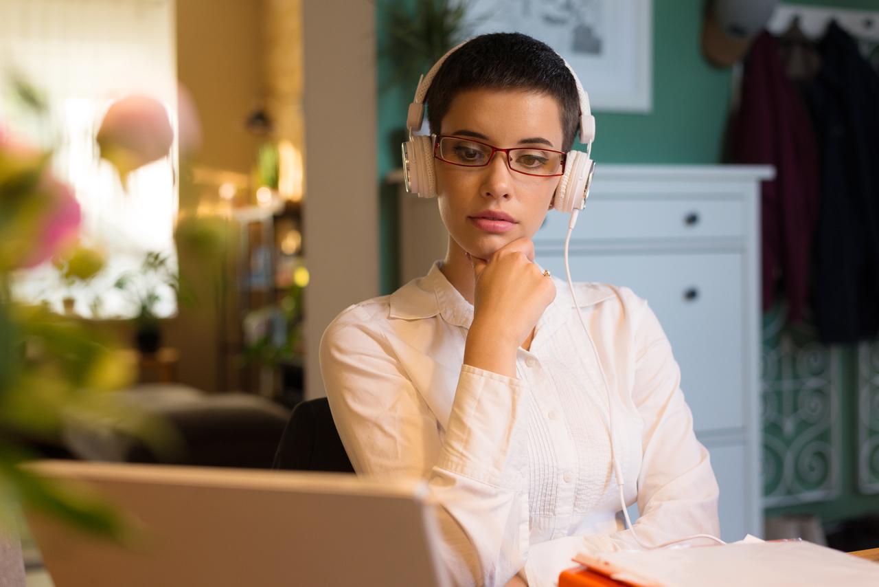 Cliente Itaú sentada observando lendo no computador sobre como reportar um golpe ao Itaú
