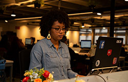 colaboradora de Institutos e fundações, concentrada em seu notebook.