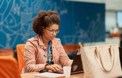 colaboradora do departamento de riscos e compliante, concentrada na tela do seu notebook.