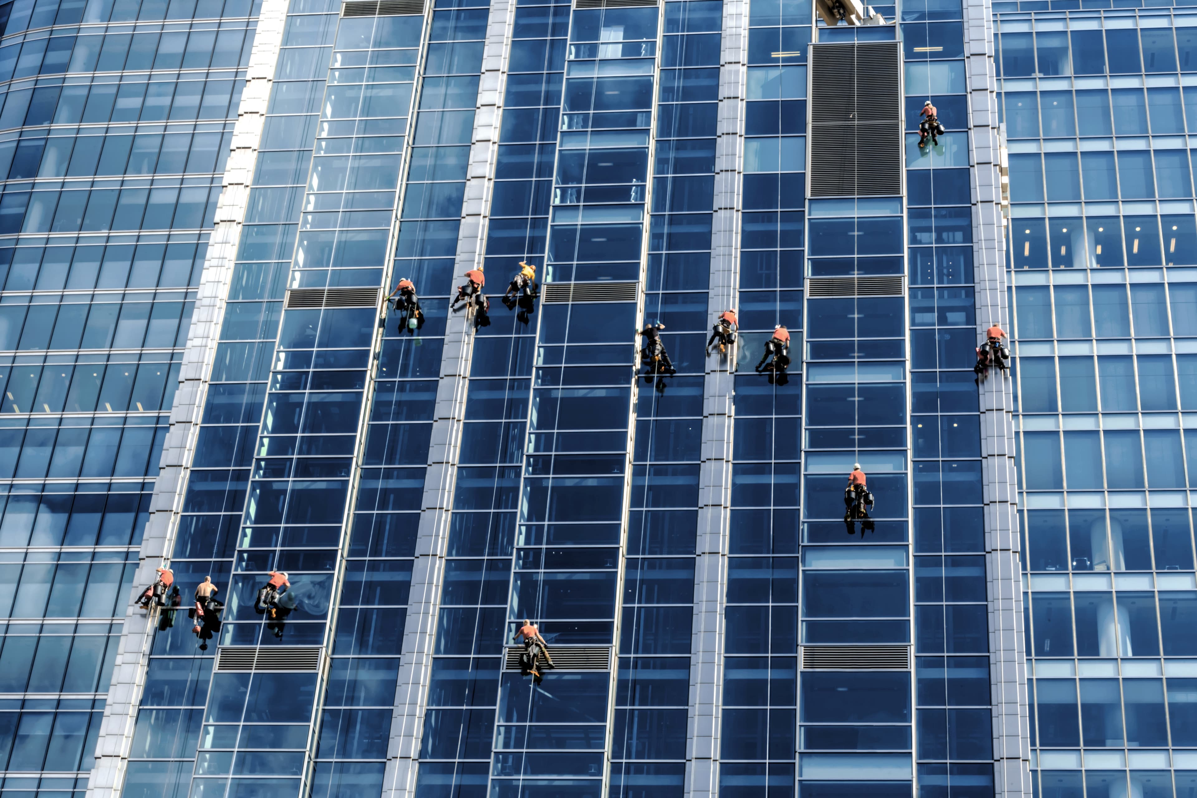 Trabalhadores em prédio espelhado em construção. Foto: Getty Images.