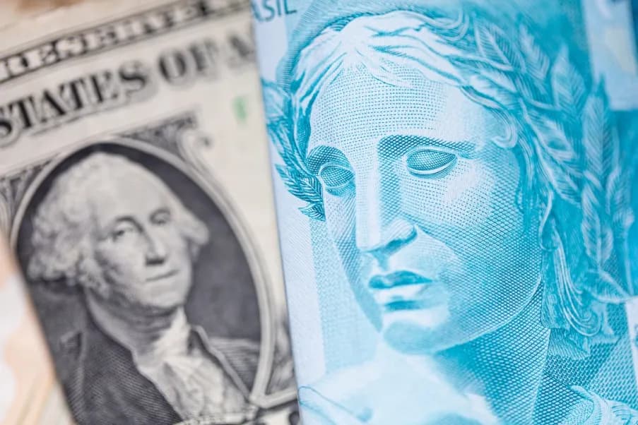 Cédulas de real e dólar lado a lado