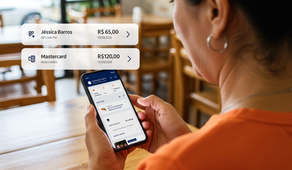 Empresária de blusa laranja, vista de costas, segura um celular com tela com app do Itaú Empresas enquanto está sentada em um estabelecimento com mesas de madeira. À esquerda, dois avisos: “Jéssica Barros — QR Code Pix — R$ 65,00 — 19/09/2026” e “Mastercard — Rede crédito — R$ 120,00 — 14/09/2026”.