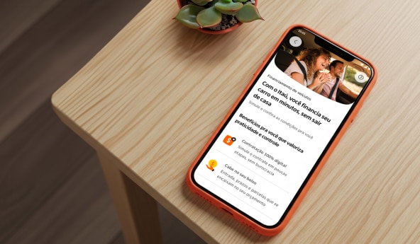 Celular sobre mesa de madeira exibe tela do app Itaú com informações sobre financiamento de veículos.