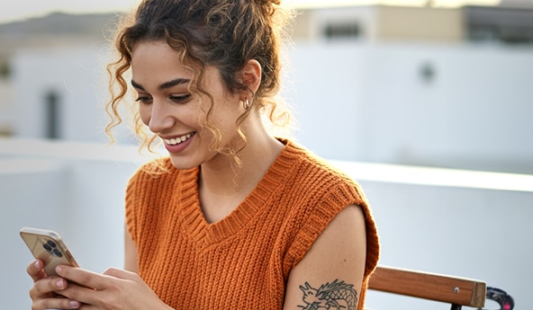 Mulher sorrindo e fazendo um Pix Automático no app Itaú