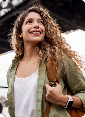 Cliente Itaú, sorrindo, segurando sua bolsa marrom