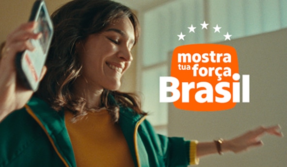 Cliente segurando celular em movimento, com roupa verde e amarela, ao lado, texto mostra tua força Brasil sobre fundo claro.