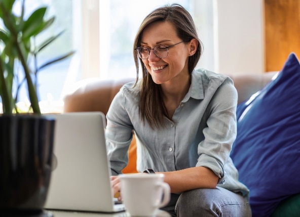Cliente Itaú Uniclass sorrindo para o notebook