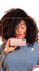 cliente Itaú mandando beijo enquanto segura um smartphone na horizontal