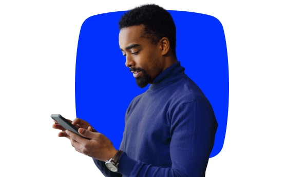 Imagem de um homem olhando para um smartphone em suas mãos enquanto acessa a inteligência de Investimentos Itaú.