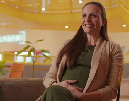 Mulher sentada em um escritório sorrindo