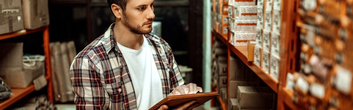 Homem em um depósito observando o estoque de produtos