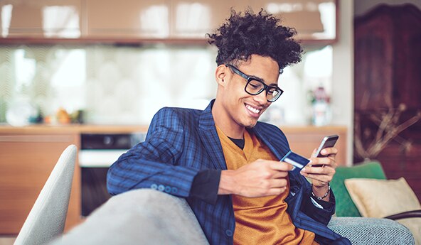 homem de óculos fazendo pagamento com o seu cartão no celular