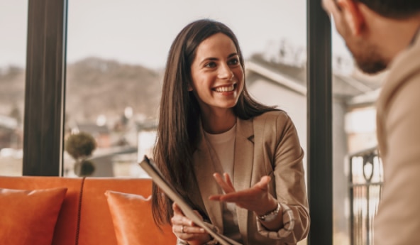 Mulher cliente Itaú sorrindo e explicando sobre o Tesouro prefixado.