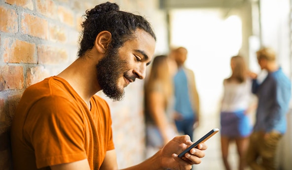 Homem mexendo no celular para representar o acesso ao perfil de crédito no app Itaú 