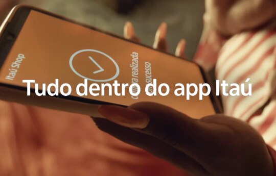 Thumbnail do vídeo sobre Itaú Shop, com uma mão segurando um celular após realizar compra no aplicativo, com o seguinte texto sobreposto "Tudo dentro do app Itaú".