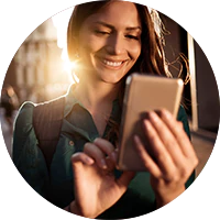 Cliente Itaú feliz enquanto acessa o app pelo seu celular.