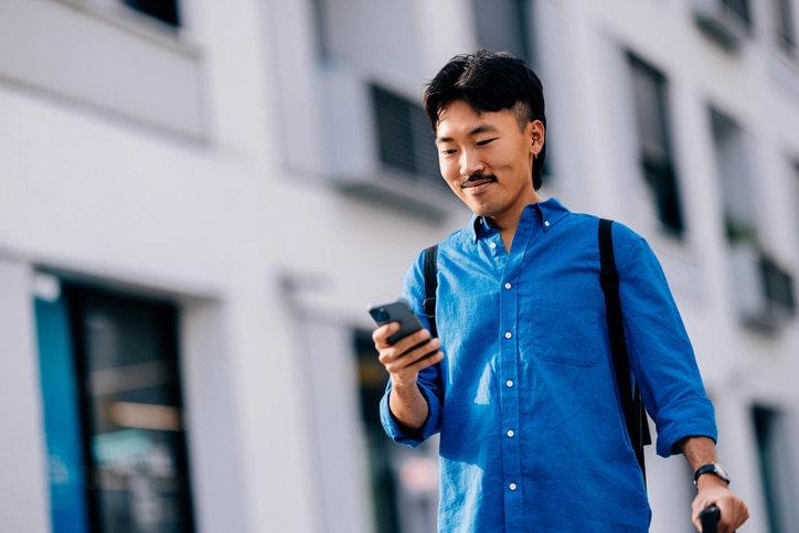 Cliente Itaú caminhando enquanto utilizando seu celular