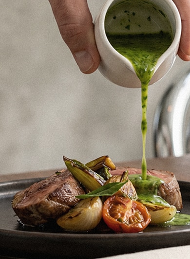 Prato gourmet recebe molho verde enquanto benefícios Fasano são apresentados ao lado.