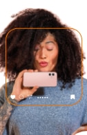 cliente Itaú mandando beijo enquanto segura um smartphone na horizontal