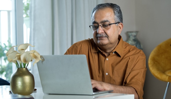 Cliente Itaú de óculos de grau, utilizando seu notebook