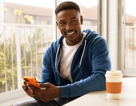 jovem sorrindo com o celular na mão