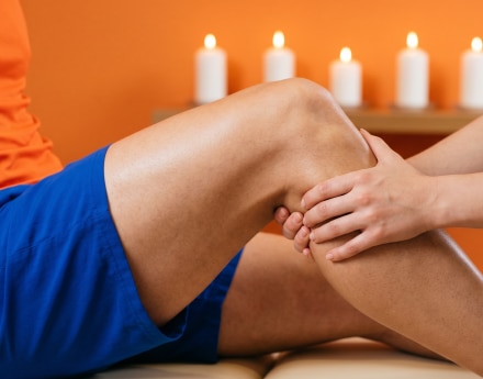 Cliente recebe massagem, peças de spa organizadas sobre fundo claro.