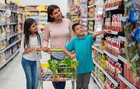 Mulher e duas crianças fazendo compras representando cliente Itaú usando o cartão pão de açúcar para ganhar pontos no programa de pontos pão de açúcar