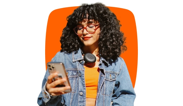 Imagem de uma mulher sorrindo enquanto acessa a inteligência de Investimentos Itaú no smartphone.