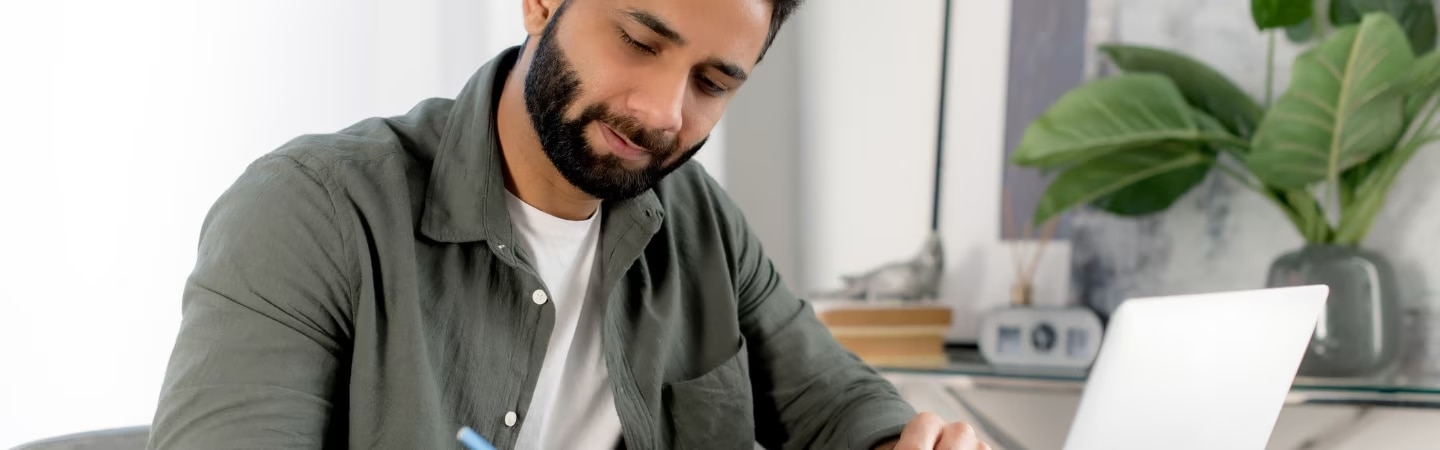 Homem em uma mesa fazendo algumas anotações