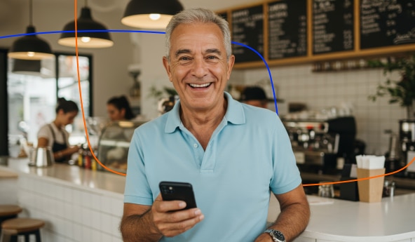 Imagem de homem cliente Itaú Procred 360 sorrindo e segurando o celular.
