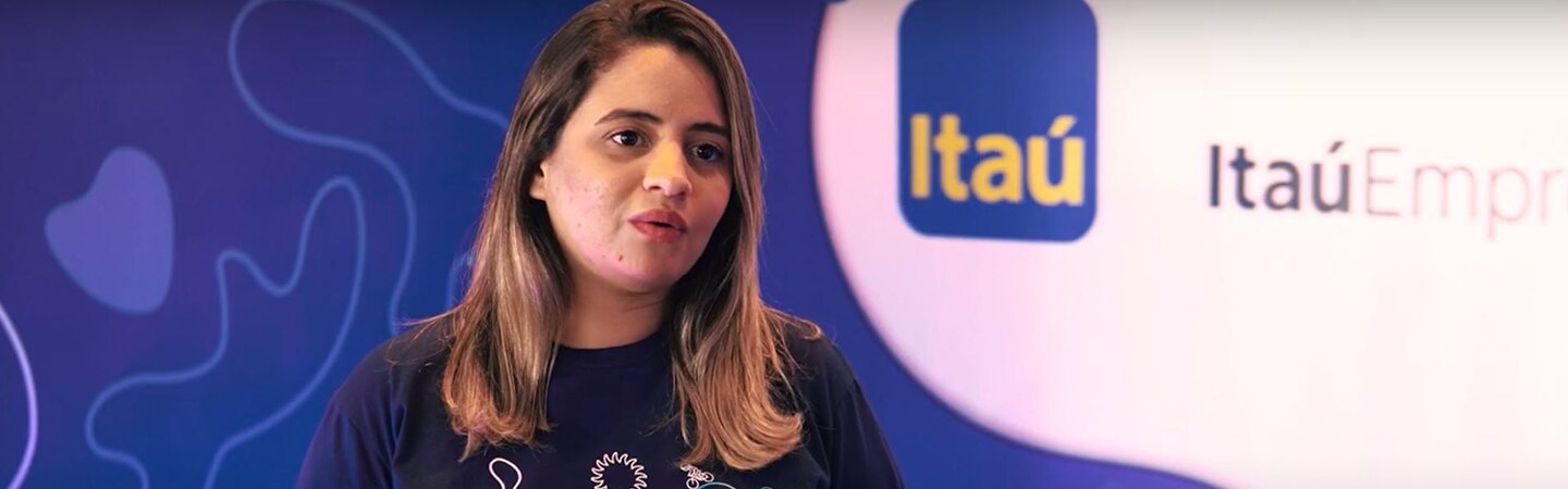 mulher dando entrevista em um fundo do Itaú