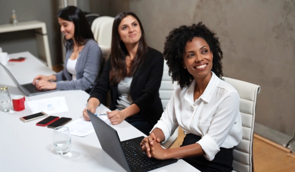 Três pessoas sentadas à mesa conhecendo mais sobre Itaú Mulher Empreendedora