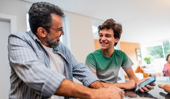 Imagem de pai e filho clientes Itaú Seguro Vida Inteira sorrindo.