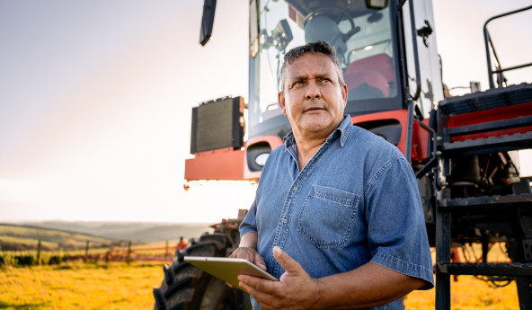 Homem_com_tablet_no_campo_com_trator